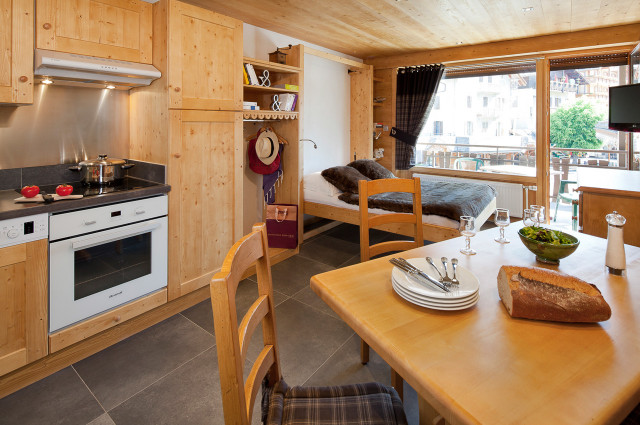 Séjour avec lit double et télévision, salle à manger et cuisine/Living room with a double bed and a television, dining room and kitchen-Forclaz C n°32-Le Grand-Bornand